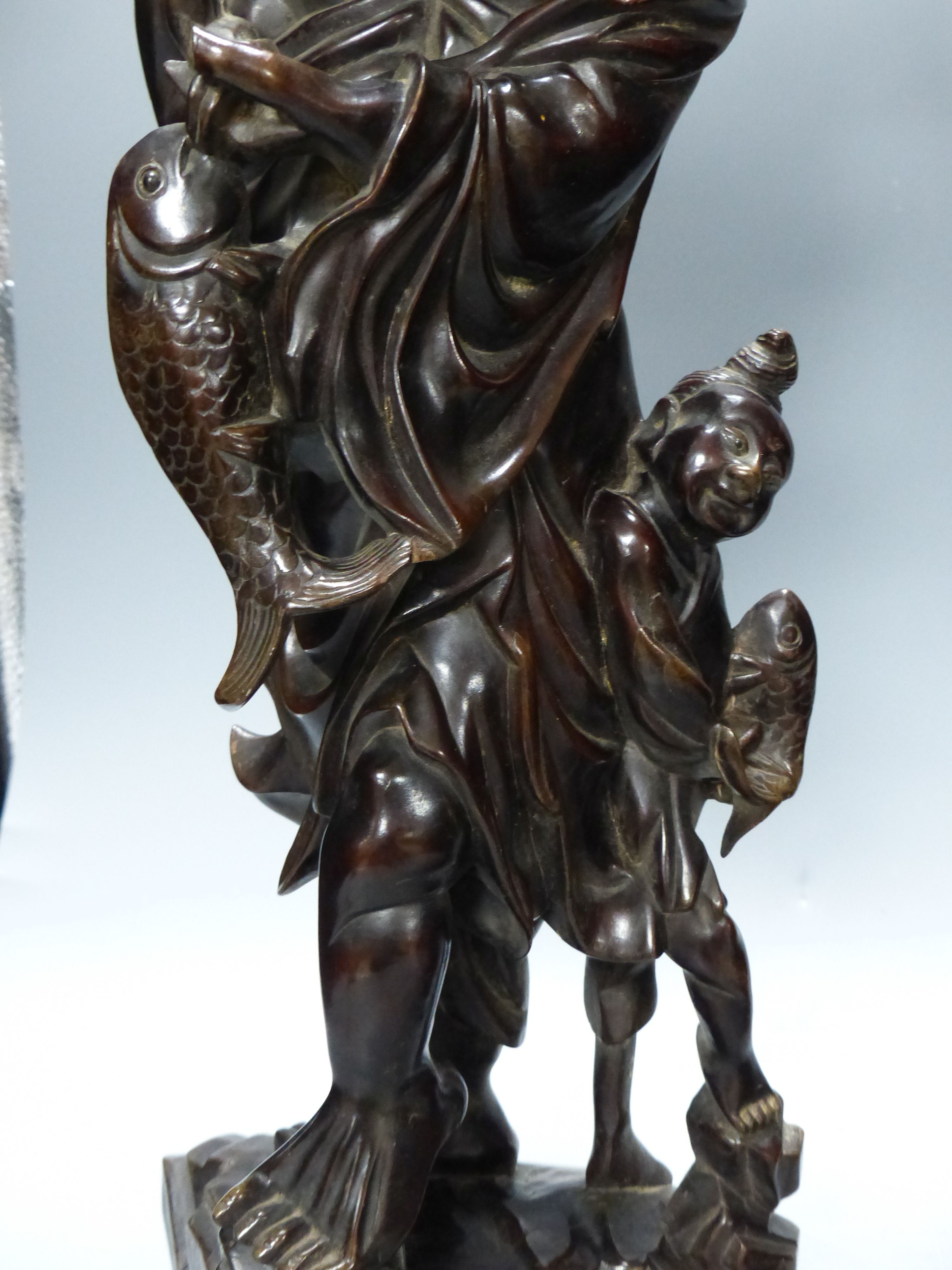 Two early 20th century Chinese hardwood figures of a demon and a fisherman, tallest 61cm